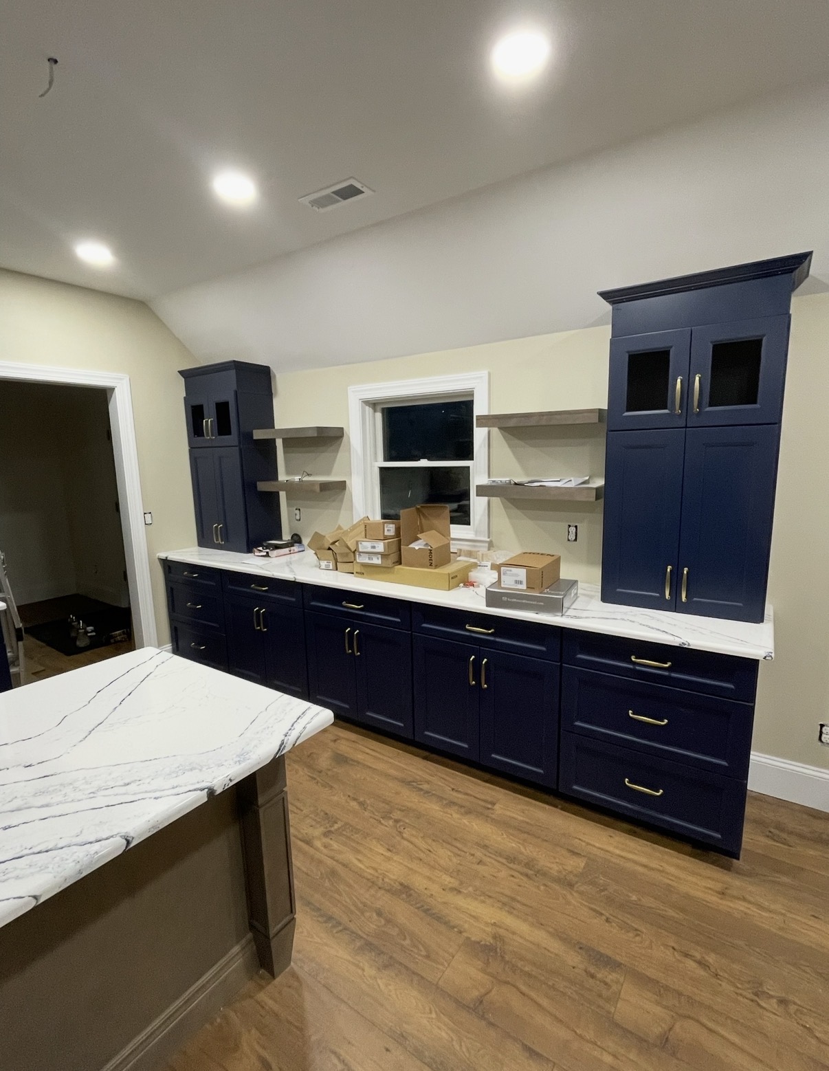 Built-in navy buffet wall with floating shelves and glass-front uppers